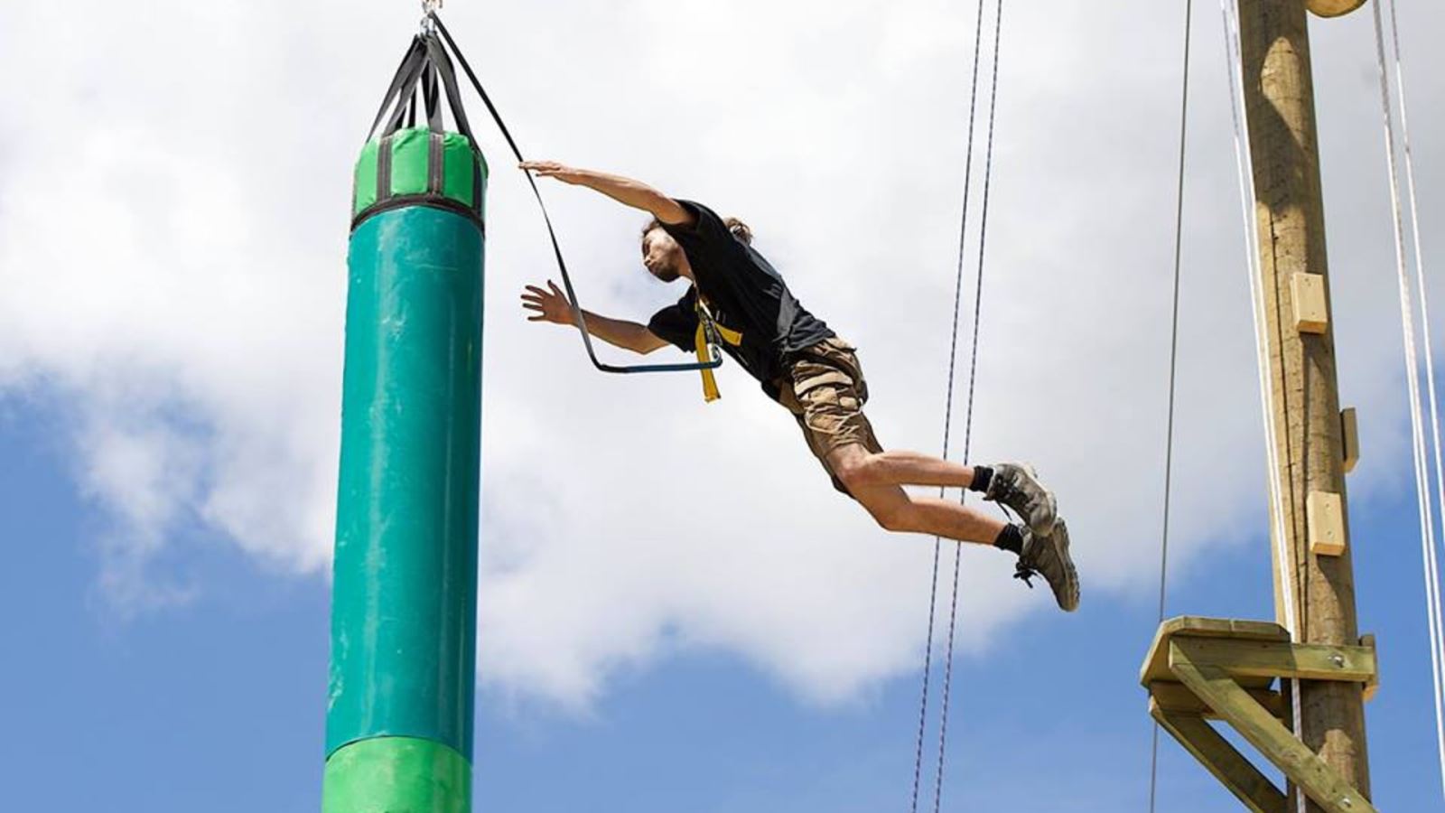 Person jumping on part of the Leap of Faith high ropes course